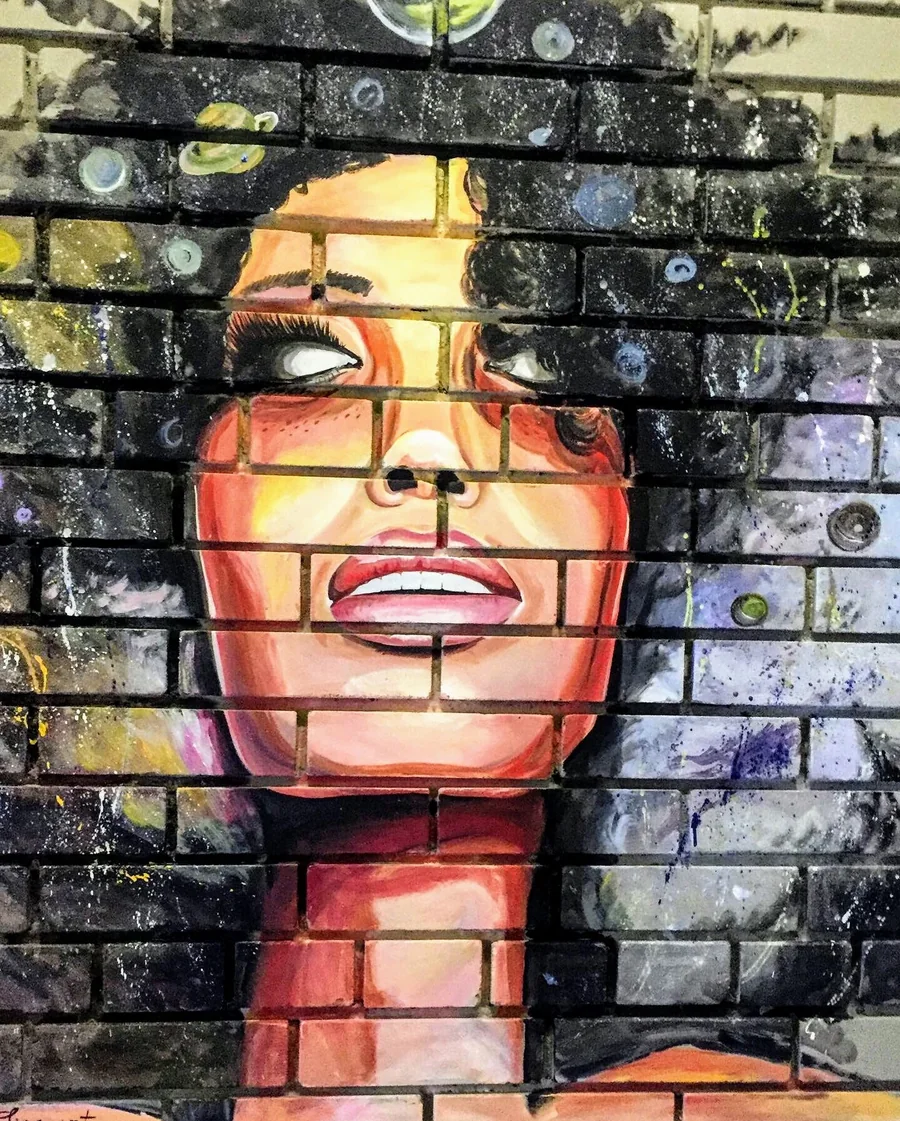 Portrait peint sur un mur de briques